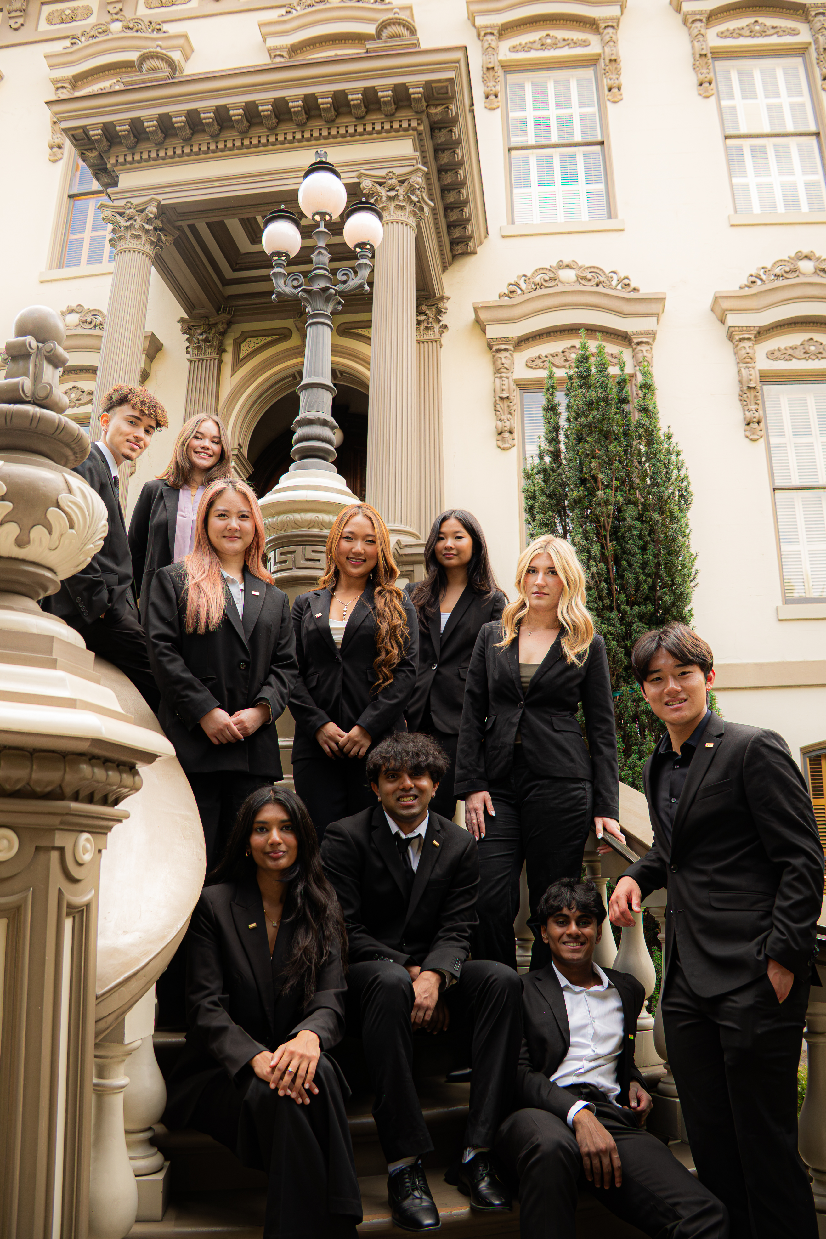 Phi Chi Theta executive board together on the steps